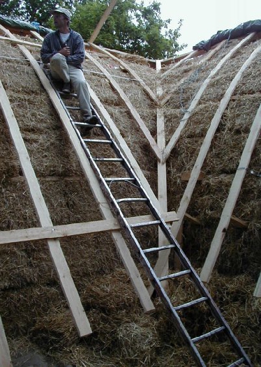 Raffinierte Dachkonstruktion: zwischen den Ballen werden Kanthölzer eingelegt, an denen die Dachsparren befestigt werden können. Auf diese Hilfskonstruktion wird quasi als Unterdachplatte Sperrholz montiert und eine regensichere Folie